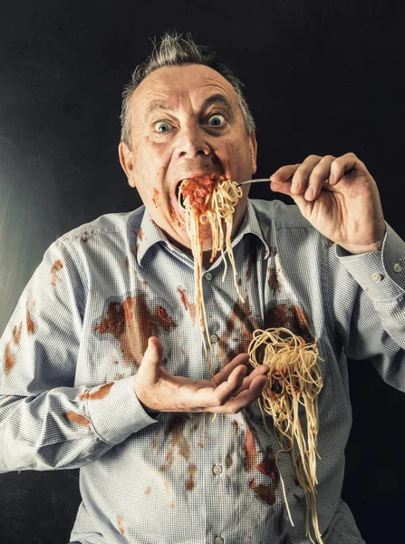 Hombre comiendo espaguetis con salsa de tomate — Foto de Stock