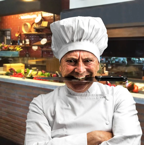 Божевільний шеф-кухар з ножем між зубами — стокове фото