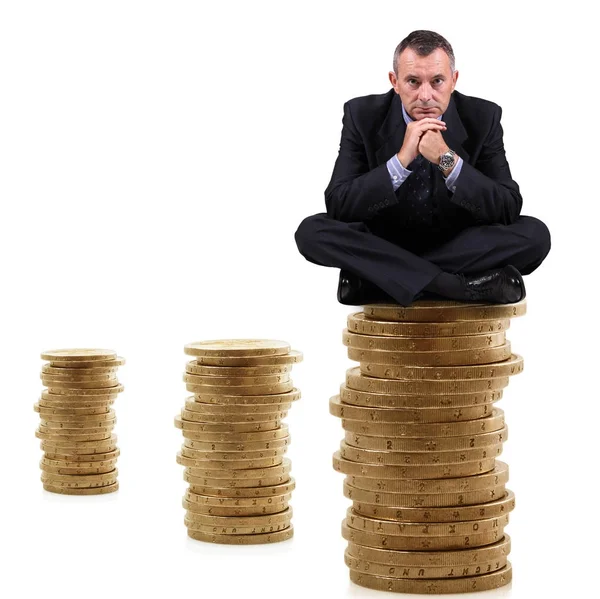Homem sentado em uma pilha de moedas — Fotografia de Stock