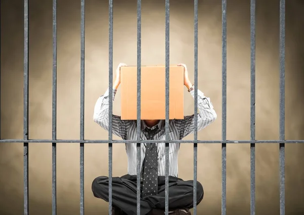 Man sitting behind the bars of a prison — Stock Photo, Image