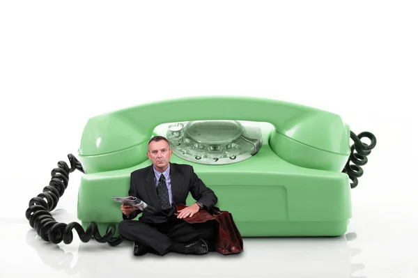 Muž sedí u starého telefonu — Stock fotografie