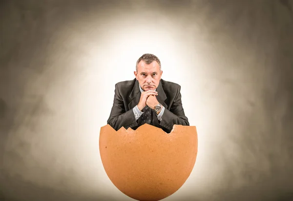 Hombre sentado en un huevo —  Fotos de Stock
