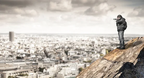 Man taking a photo on top a rock — Stock Photo, Image