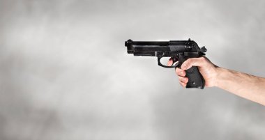 gri arka planda silahla el