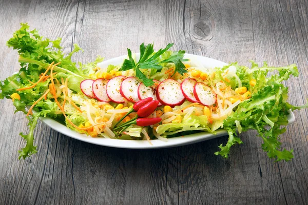Salada com rabanete e mais na mesa de madeira — Fotografia de Stock