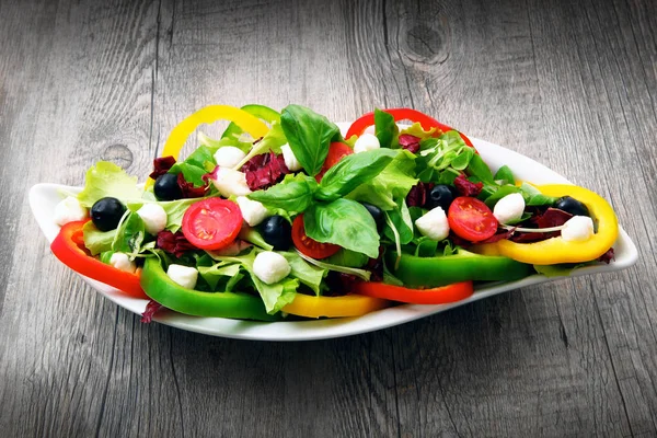 Salade aux tomates, poivrons d'olive et fromage sur table en bois — Photo