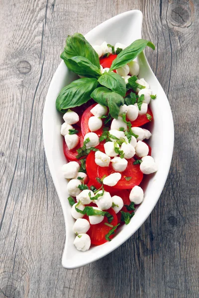 Salad caprese on wooden table — Stock Photo, Image