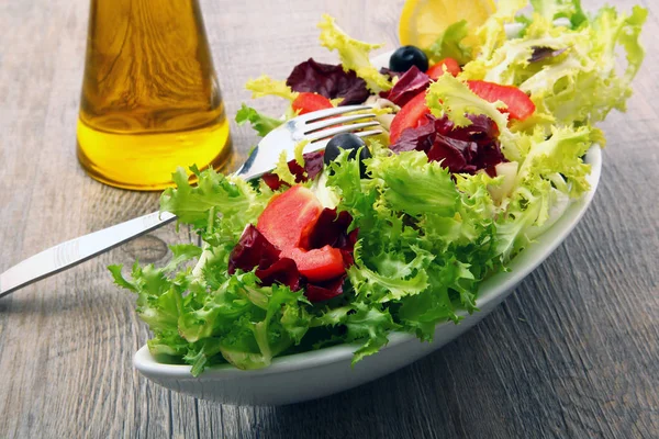 Салат с помидорами и оливками на деревянном столе — стоковое фото
