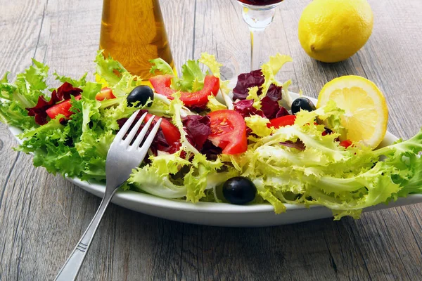 Salada com tomates e azeitona em mesa de madeira — Fotografia de Stock