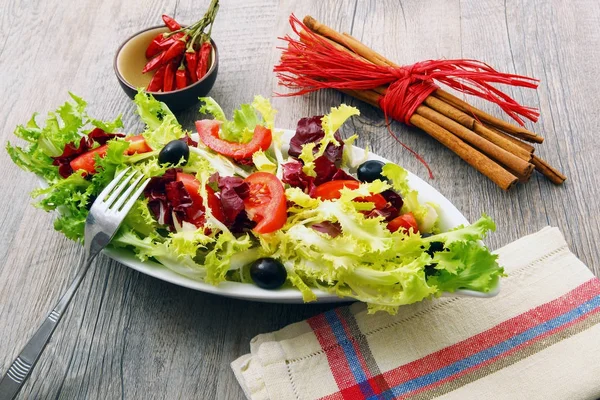 Ensalada con tomates y aceitunas sobre mesa de madera —  Fotos de Stock