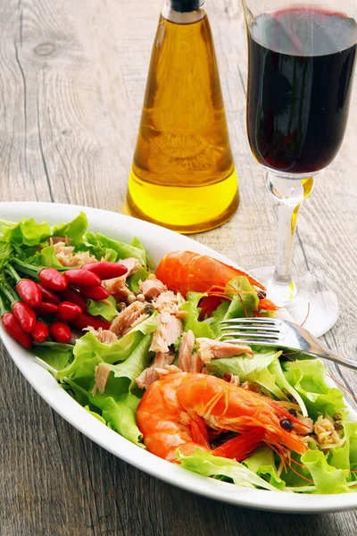 Salada com camarão e atum em mesa de madeira — Fotografia de Stock