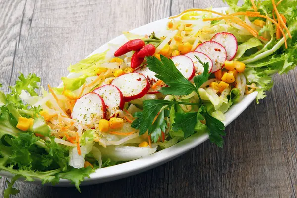 Salada com rabanete e mais na mesa de madeira — Fotografia de Stock