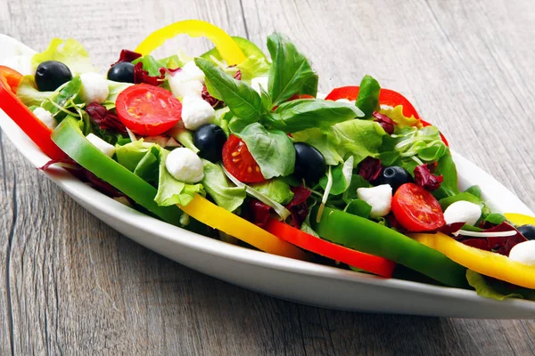 Salade aux tomates, poivrons d'olive et fromage sur table en bois — Photo