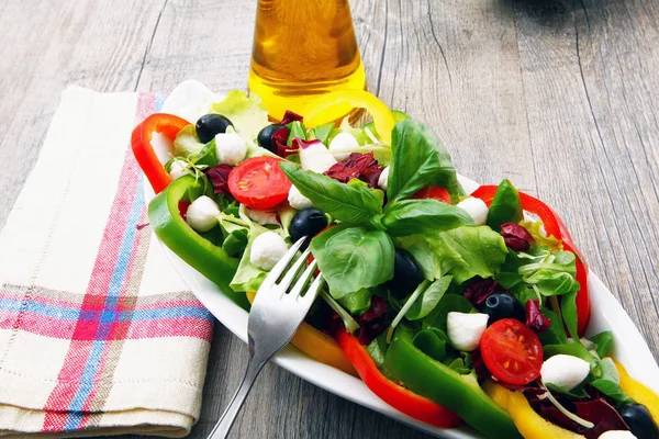 Salada com tomate, pimentão de azeitona e queijo em mesa de madeira — Fotografia de Stock