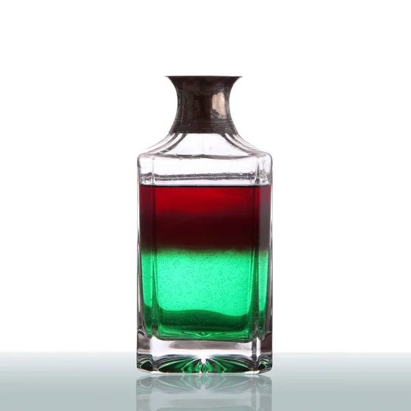 Botella con líquido rojo y verde en fondo blanco — Foto de Stock