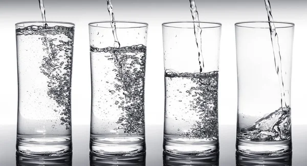 Water filling glasses in sequence