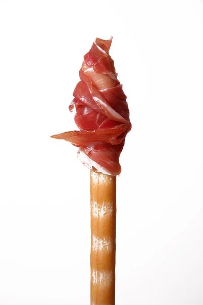 Jamón crudo enrollado en un palo de pan —  Fotos de Stock