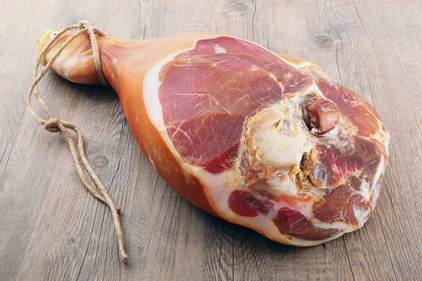 Coscia di prosciutto crudo su fondo di legno — Foto Stock