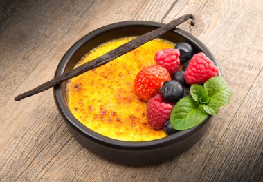 Creme brulee ahşap arka planda çilek ile
