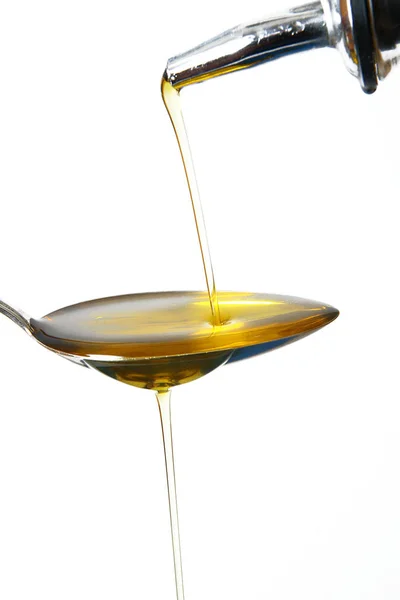 Azeite de oliva sobre colher em fundo branco — Fotografia de Stock