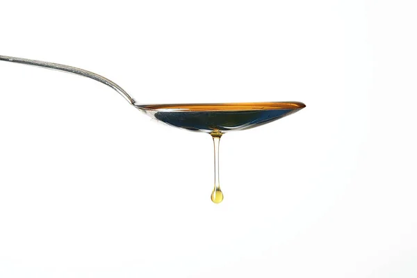 Aceite de oliva sobre cuchara en fondo blanco — Foto de Stock