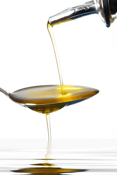 Olio d'oliva su cucchiaio su fondo bianco — Foto Stock