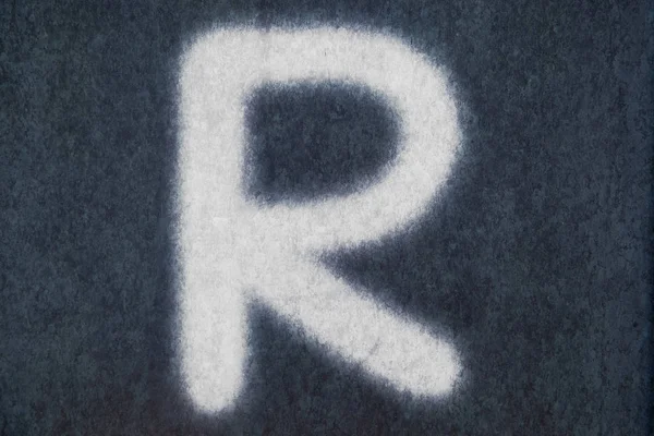 List na białym tle kreda R w tablica tło — Zdjęcie stockowe