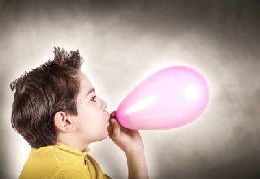 bir balon şişirme oynayan çocuk