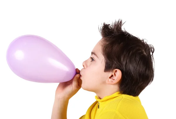 Αγόρι παίζει φουσκώνοντας ένα μπαλόνι σε λευκό φόντο — Φωτογραφία Αρχείου