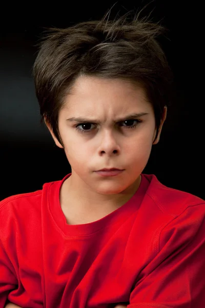 Wütender kleiner Junge im dunklen Hintergrund — Stockfoto