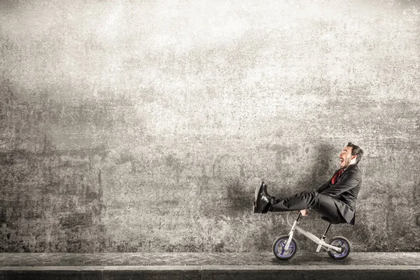 Manager with small bicycle in dangerous situation — Stock Photo, Image