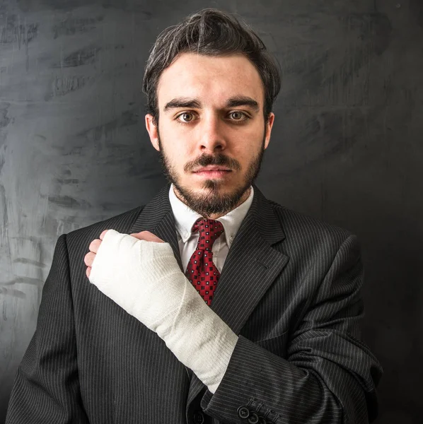 Fiatal üzletember leadott karját, sötét háttér — Stock Fotó