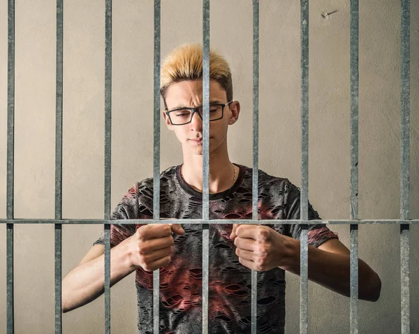 Young man behind bars — Stock Photo, Image