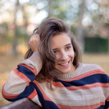 Bir kız bankta oturur ve sonbahara hayran kalır. Sonbaharda bir bankta otururken güzel bir kız gülümser..