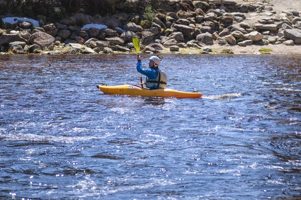 Mann auf dem Kajak. Ein Mann am Ufer des Flusses ruht sich aus, gießt Wasser aus Booten und trägt Kajak zum Fluss.. — Stockfoto