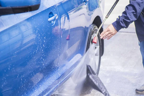 Lavado manual del coche con agua a presión en el lavado del coche exterior.Limpieza del coche con agua de alta presión . — Foto de Stock