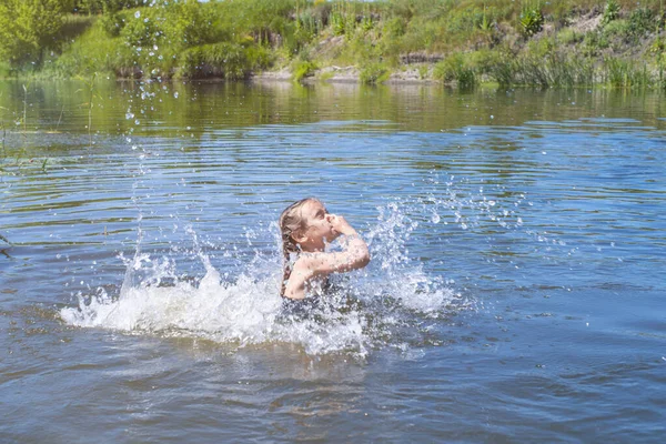 Kislány fut át a víz egy csobbanás. az ő kezében ruhával. — Stock Fotó