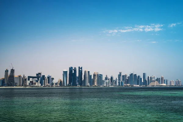 Doha, Katar - 4 Ağustos 2018: Doha modern şehir palmiye ağacı, arabalar, şehirde Doha, Katar başkenti mavi bir gökyüzü üzerinde geniş caddeleri ile.