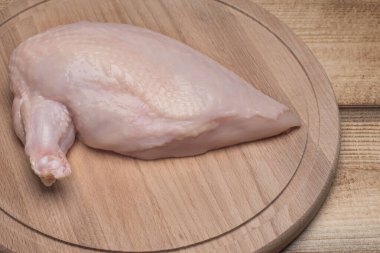 Tahtada çiğ tavuk eti. Taze tavuk eti. Tahta bir kanatlı taze tavuk filetosu. Sağlıklı beslenme. Harika Chiken..