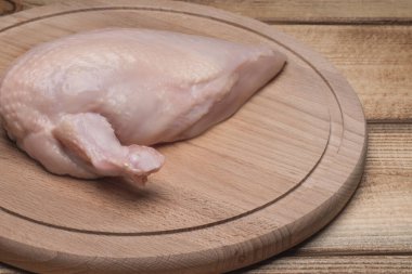 Tahtada çiğ tavuk eti. Taze tavuk eti. Tahta bir kanatlı taze tavuk filetosu. Sağlıklı beslenme. Harika Chiken..