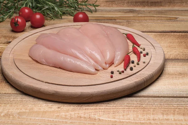 Rauwe, frisse kleine kipfilet. Kleine binnenste kipfilet op een houten snijplank. — Stockfoto