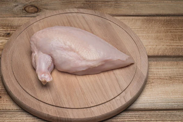 Carne crua de frango em tábua de madeira. Carne fresca de frango. Filé de frango fresco com uma asa em uma placa de corte de madeira.Alimentação saudável.Chiken supremo . — Fotografia de Stock