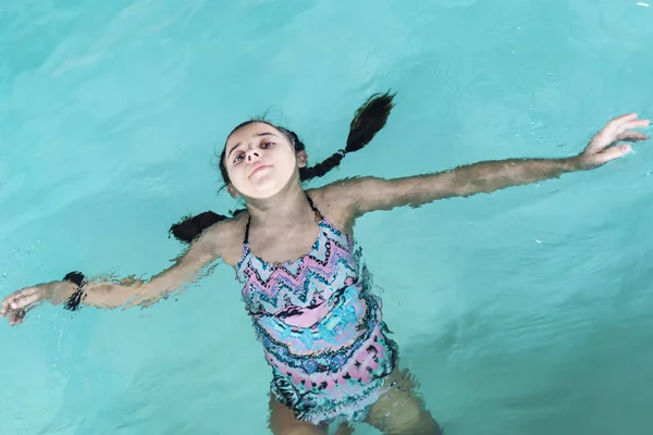 Meisje duik in het zwembad. Gelukkig meisje speelt in de poule. Mooi meisje zwemmen en plezier in het water. Actieve vakantie. — Stockfoto