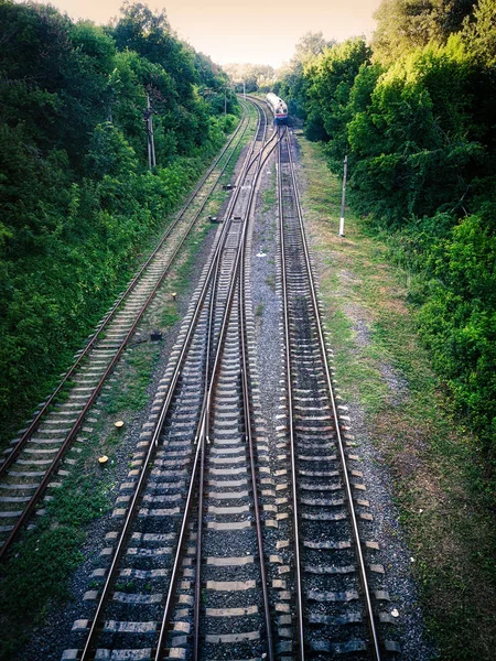 Železniční kolejnice s odjíždějícím vlakem. Železniční kolejnice. — Stock fotografie