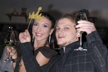 12.13.2019 Slovakya. Nitra. Bir erkekle bir kız bardaktan içiyor. Kız ve erkek bir partide. Erkekler ve kadınlar doğum gününü ya da yeni yıl partisini kutluyor. .