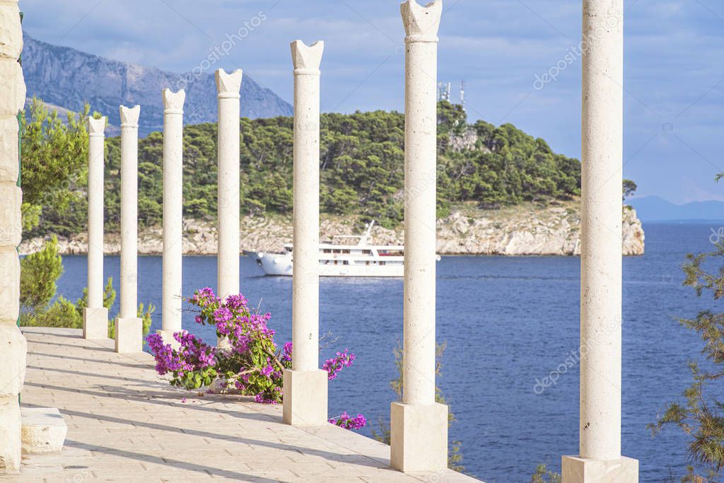 Seaside promenade. Greek-style columns on the promenade at the foot of the Dolomite mountains.