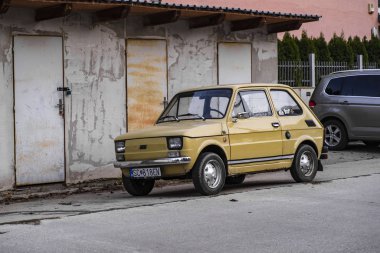 Otoparktaki eski küçük araba. Sarı eski araba. Retro arabalar.