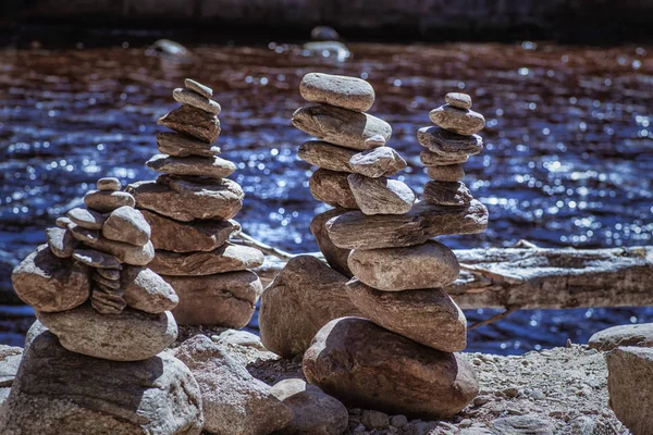 Pedras fluviais são revestidas com piromidas. Um equilíbrio de pedras fluviais, conceito de equilíbrio. Pedra de equilíbrio em uma rocha  . — Fotografia de Stock