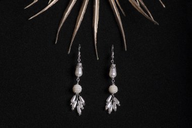 Siyah arka planda el yapımı küpeler. Yakın plan, seçici odaklanma. Mücevherler. Kadın mücevherleri..