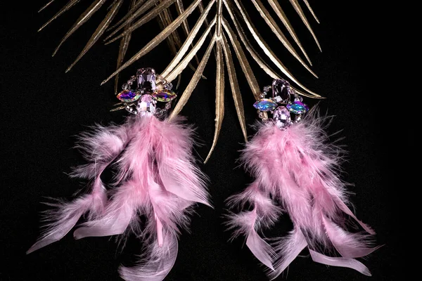 Ohrringe aus rosa Federn auf schwarzem Hintergrund in Nahaufnahme, selektiver Fokus. Schmuck. Damenschmuck. — Stockfoto